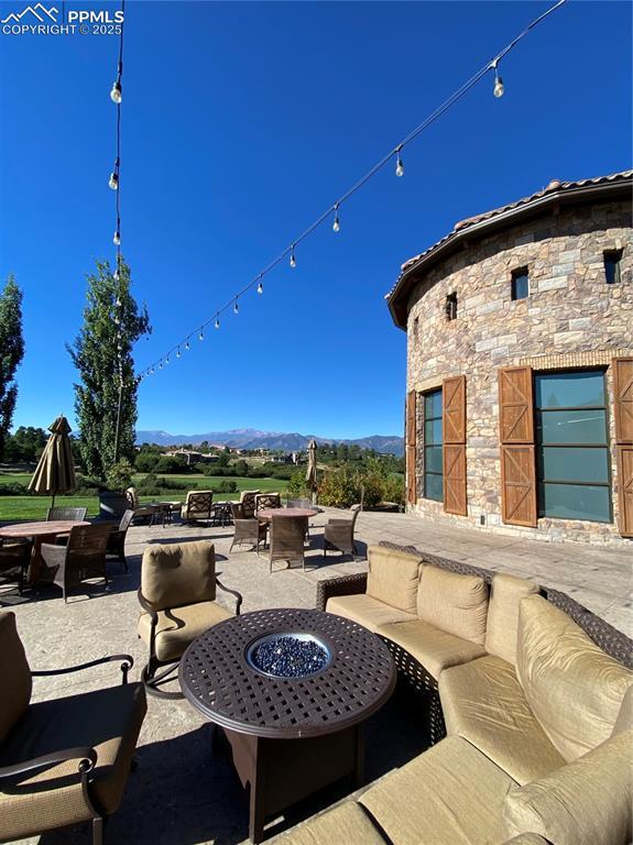 view of patio featuring a mountain view and an outdoor living space with a fire pit