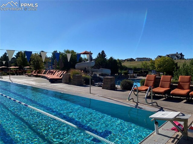 pool featuring a diving board and a patio area