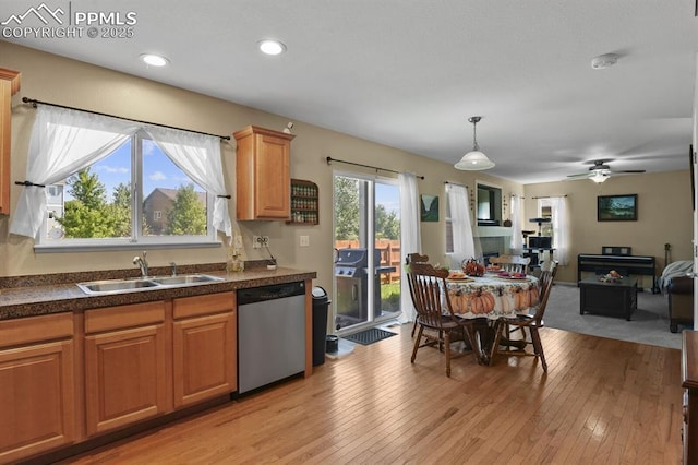 kitchen featuring sink, hanging light fixtures, dishwasher, and light wood-type flooring