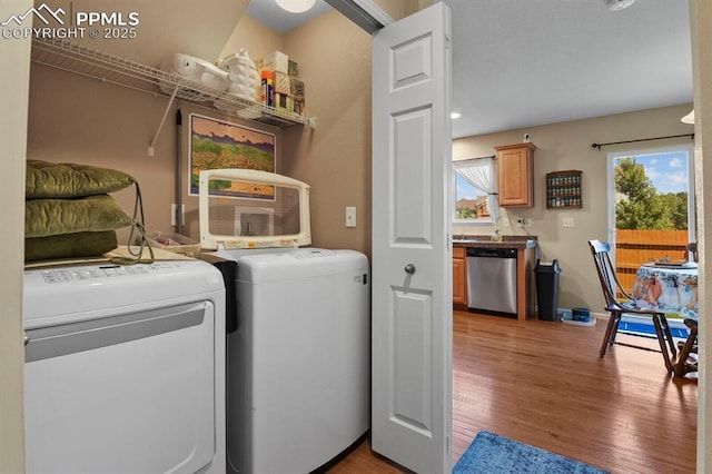 clothes washing area featuring washing machine and dryer and light hardwood / wood-style floors