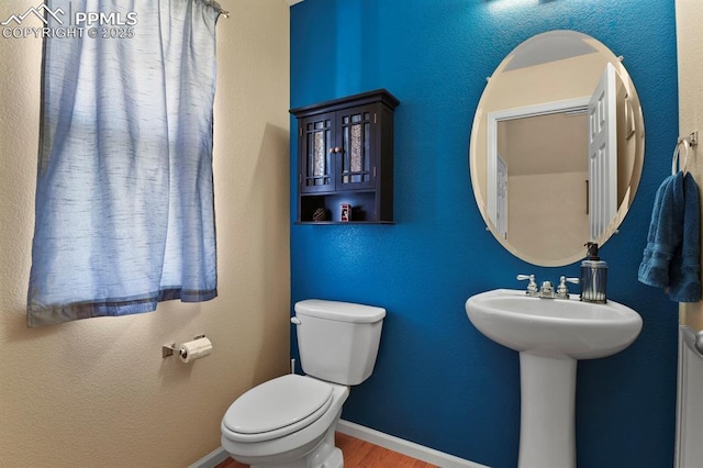 bathroom with hardwood / wood-style flooring and toilet