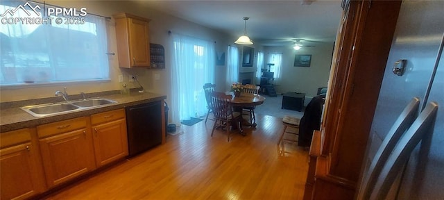 kitchen featuring sink, decorative light fixtures, light hardwood / wood-style flooring, dishwasher, and a healthy amount of sunlight