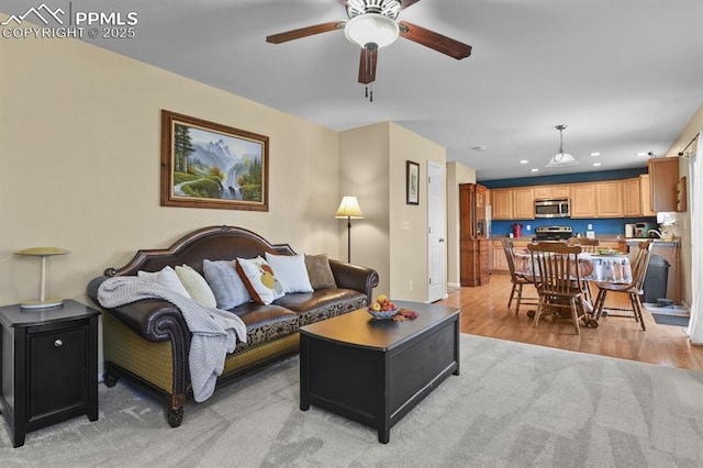 living room with ceiling fan and light hardwood / wood-style floors