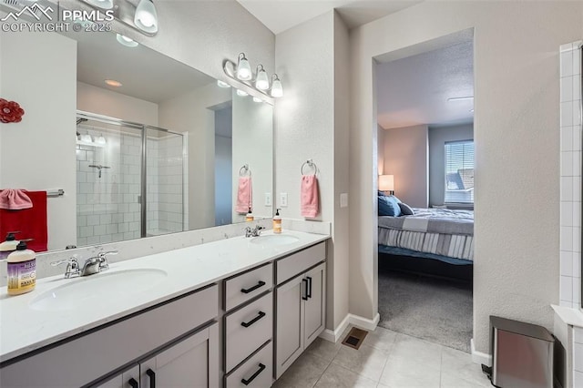 bathroom with vanity, a shower with door, and tile patterned flooring