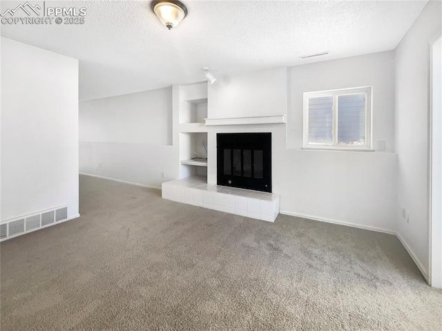 unfurnished living room featuring carpet, a fireplace, and a textured ceiling