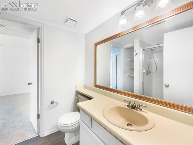 bathroom featuring vanity, toilet, and a shower with door