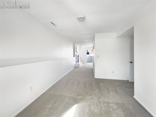 hall featuring carpet floors and a textured ceiling