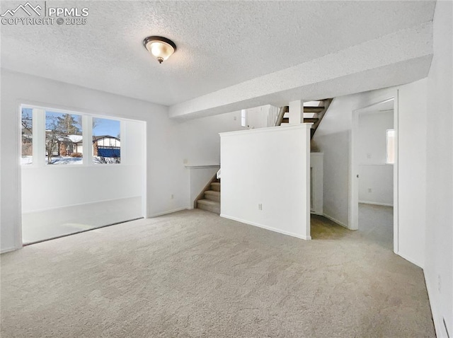 carpeted spare room featuring a textured ceiling