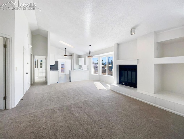 unfurnished living room with ceiling fan, lofted ceiling, carpet floors, and a textured ceiling