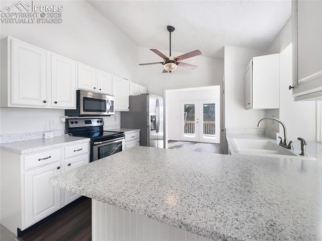 kitchen featuring stainless steel appliances, kitchen peninsula, and white cabinets