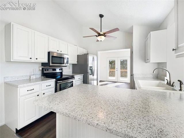 kitchen featuring french doors, sink, appliances with stainless steel finishes, kitchen peninsula, and white cabinets