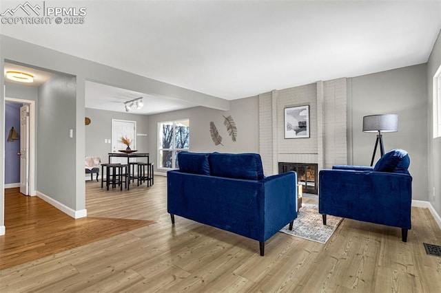 living room with a fireplace and light hardwood / wood-style flooring