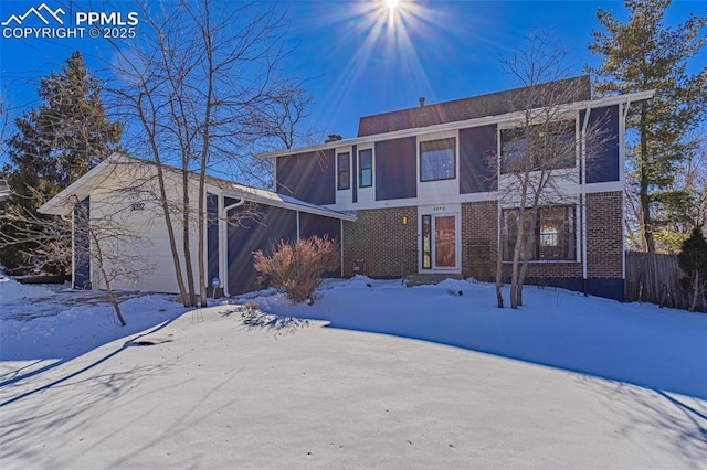 snow covered property with a garage