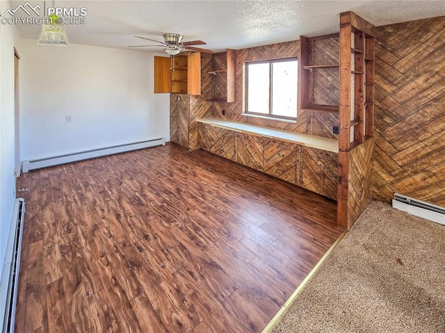 kitchen featuring ceiling fan, dark wood-type flooring, a baseboard radiator, and a textured ceiling