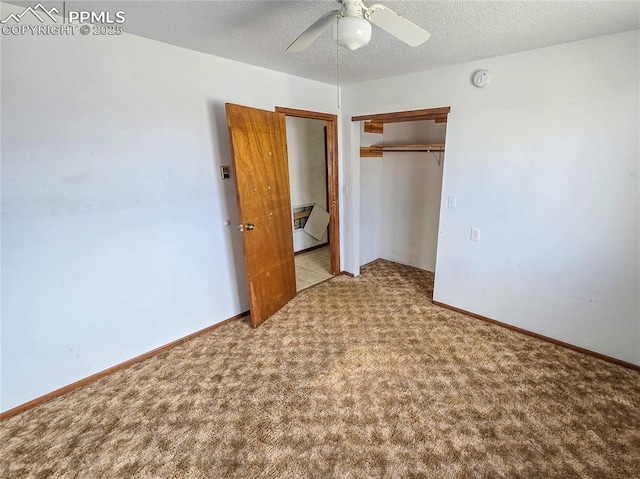 unfurnished bedroom with ceiling fan, light colored carpet, a closet, and a textured ceiling