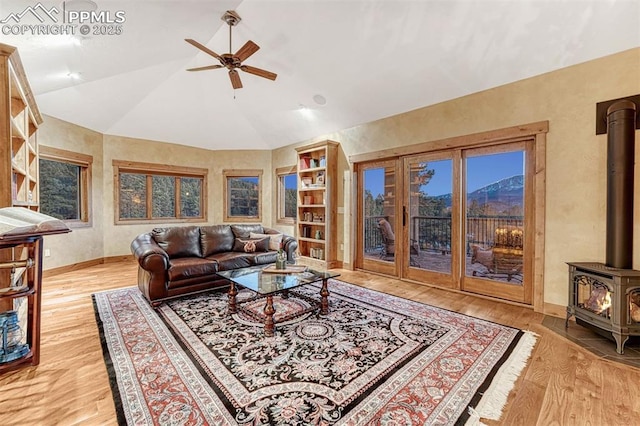 201 Fox Mountain Dr, Woodland Park, CO 80863 - living room with vaulted ceiling, a wood stove, and light wood-type flooring