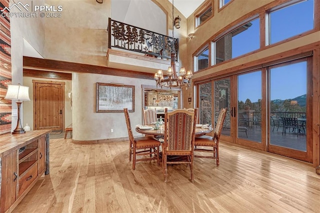 201 Fox Mountain Dr, Woodland Park, CO 80863 - dining room with a notable chandelier, a towering ceiling, and light hardwood / wood-style flooring