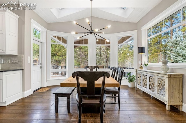 sunroom featuring lofted ceiling with skylight and a notable chandelier