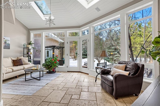 sunroom / solarium with plenty of natural light, french doors, and vaulted ceiling with skylight