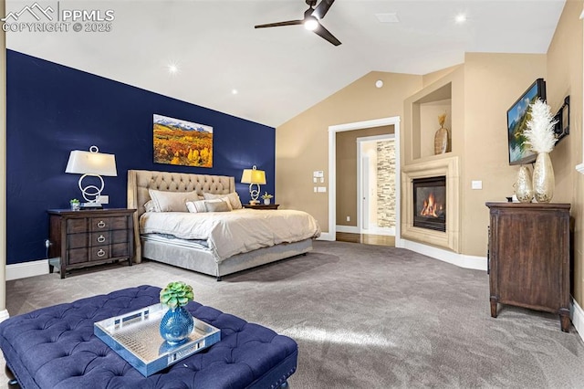 carpeted bedroom with a fireplace, ceiling fan, and vaulted ceiling