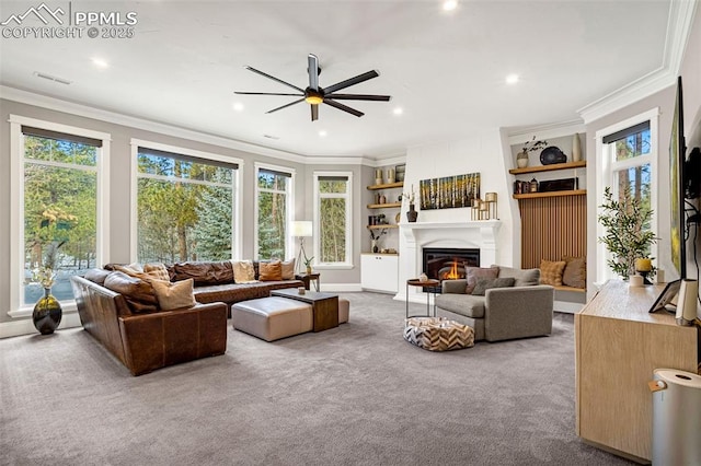 carpeted living room with ornamental molding and ceiling fan