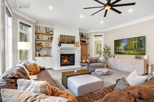 living room with crown molding, carpet flooring, ceiling fan, and built in shelves