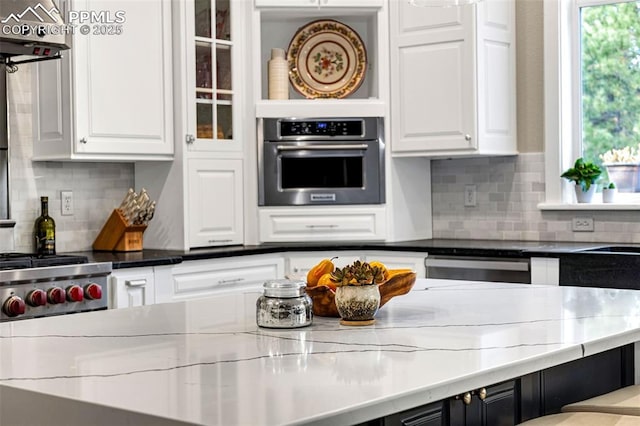 kitchen featuring white cabinetry, backsplash, and stainless steel appliances