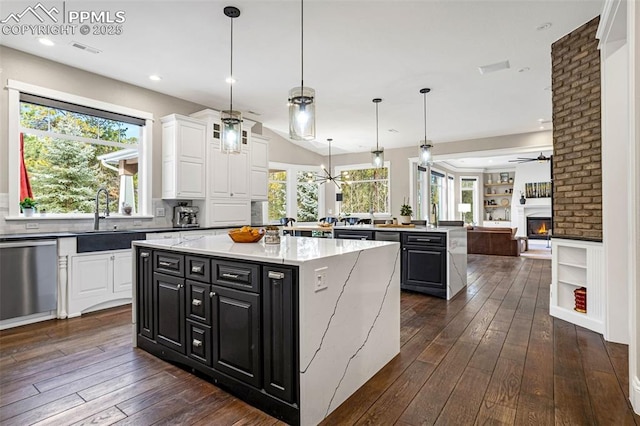 kitchen featuring sink, white cabinetry, a center island, hanging light fixtures, and dishwasher