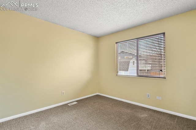 carpeted spare room with a textured ceiling