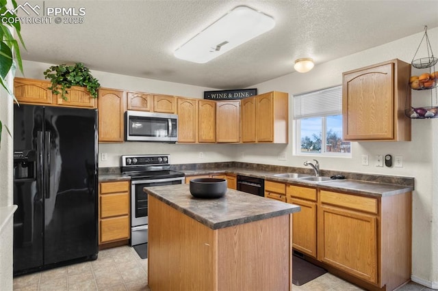 kitchen featuring sink, black appliances, a center island, and a textured ceiling