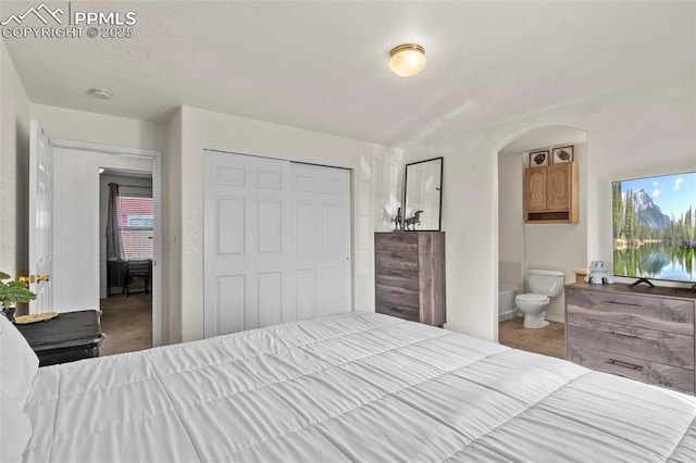 carpeted bedroom with multiple windows, connected bathroom, and a closet