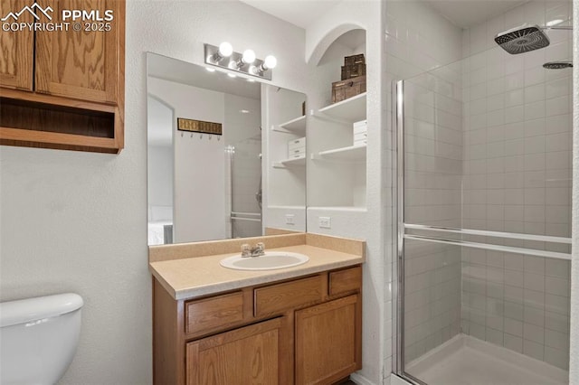 bathroom with vanity, an enclosed shower, and toilet