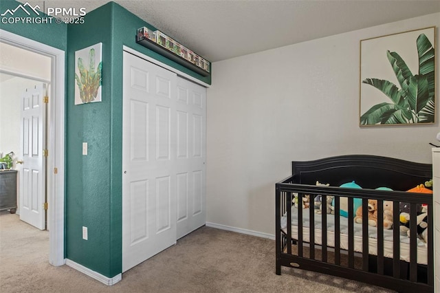 bedroom with a nursery area, a closet, and carpet