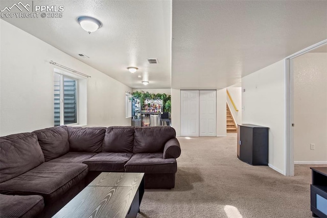 carpeted living room featuring a textured ceiling