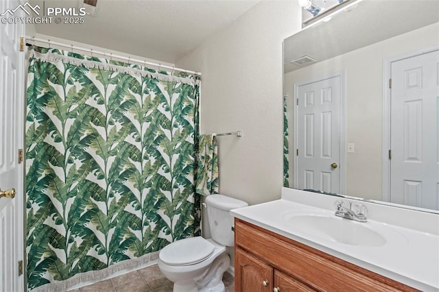 bathroom featuring vanity, tile patterned floors, and toilet