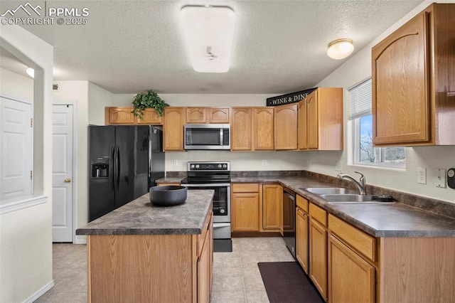 kitchen featuring sink, black appliances, a center island, and a textured ceiling