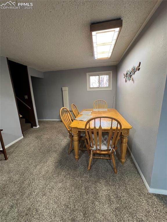 dining space with carpet and a textured ceiling