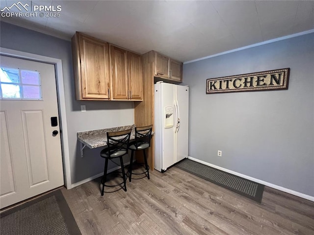 kitchen featuring white refrigerator with ice dispenser and light hardwood / wood-style flooring