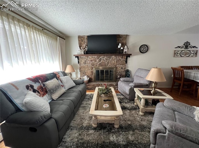 living room with hardwood / wood-style flooring, a fireplace, and a textured ceiling