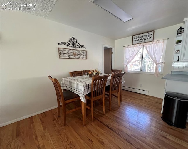 dining room with a baseboard radiator and wood-type flooring