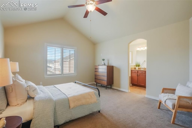 bedroom featuring light carpet, connected bathroom, lofted ceiling, and ceiling fan