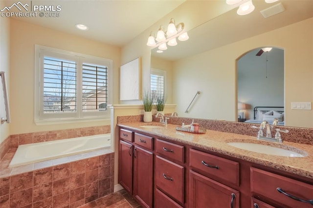 bathroom with vanity and a relaxing tiled tub