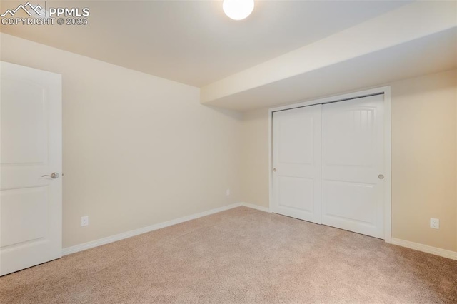 unfurnished bedroom with light colored carpet and a closet