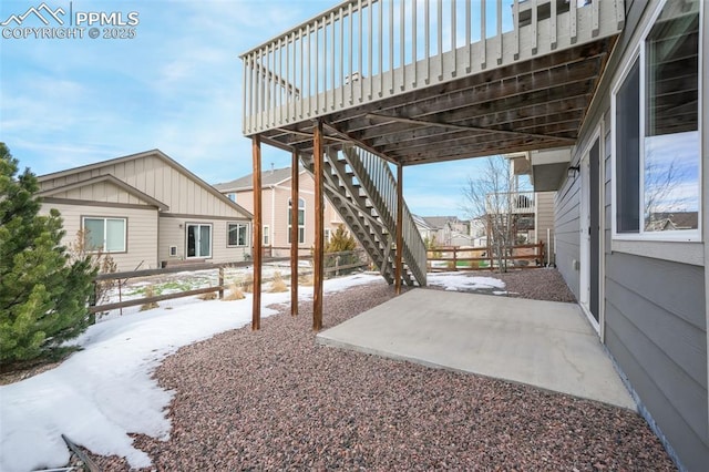 snow covered patio featuring a carport