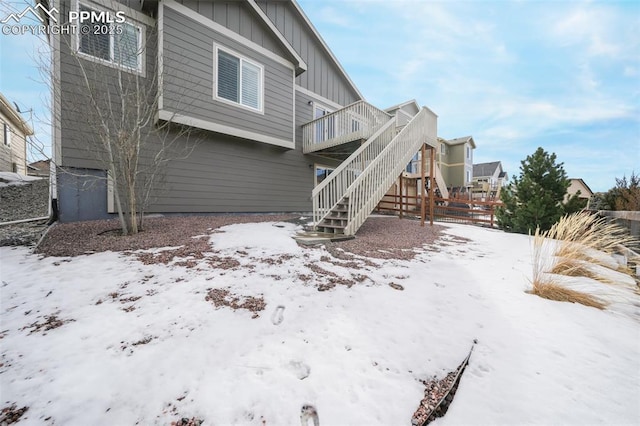 snow covered rear of property featuring a wooden deck