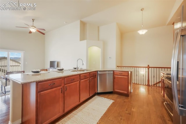 kitchen with pendant lighting, sink, ceiling fan, light hardwood / wood-style floors, and stainless steel appliances