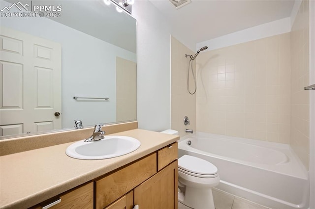 full bathroom featuring tiled shower / bath, vanity, tile patterned floors, and toilet