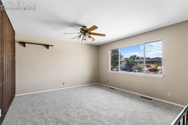 carpeted spare room with ceiling fan