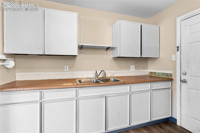 kitchen featuring dark hardwood / wood-style flooring, sink, and white cabinets