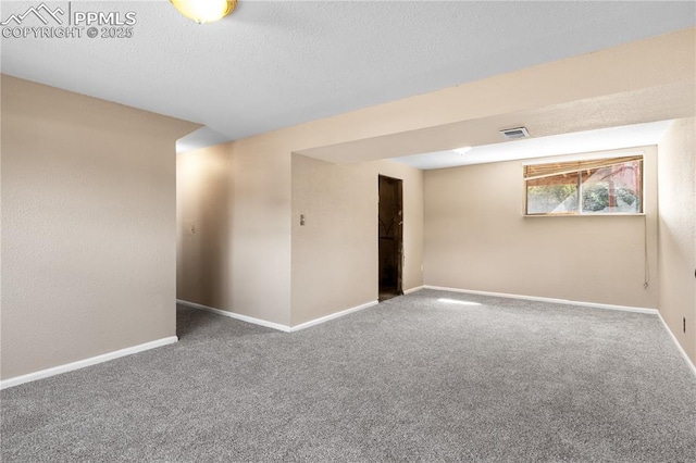 carpeted spare room with a textured ceiling